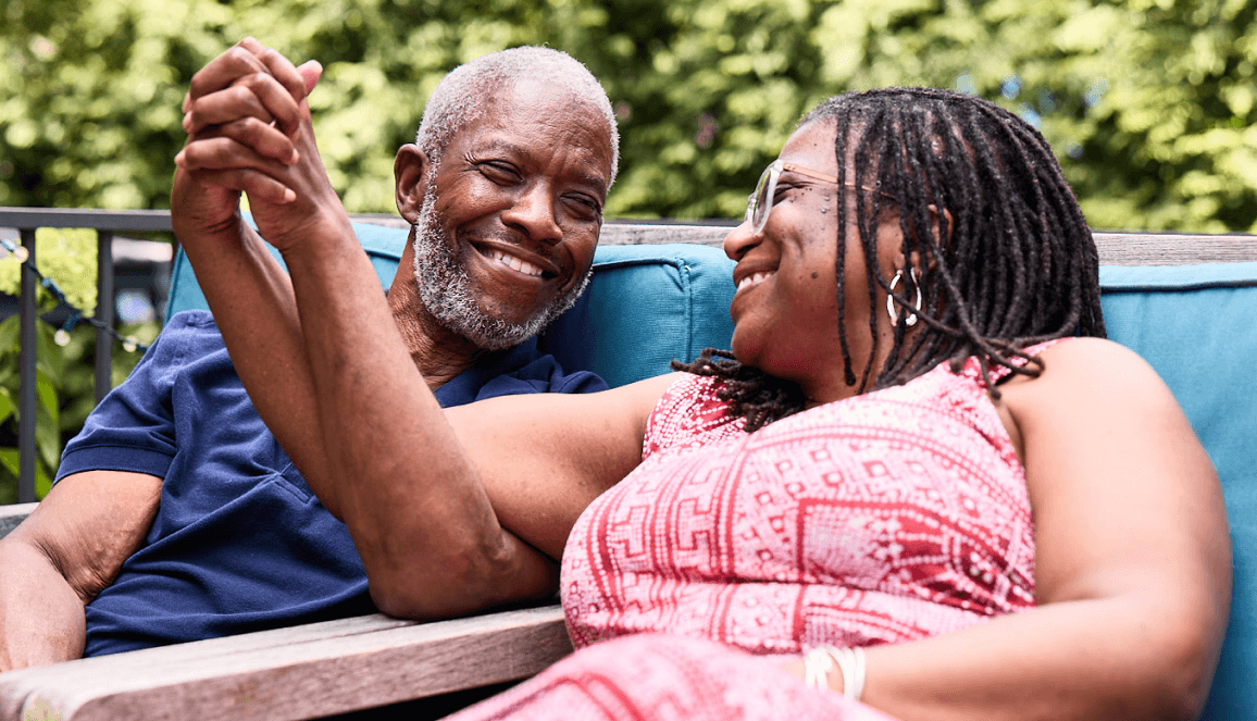 Bob and his wife, Cynthia, outdoors holding hands and smiling